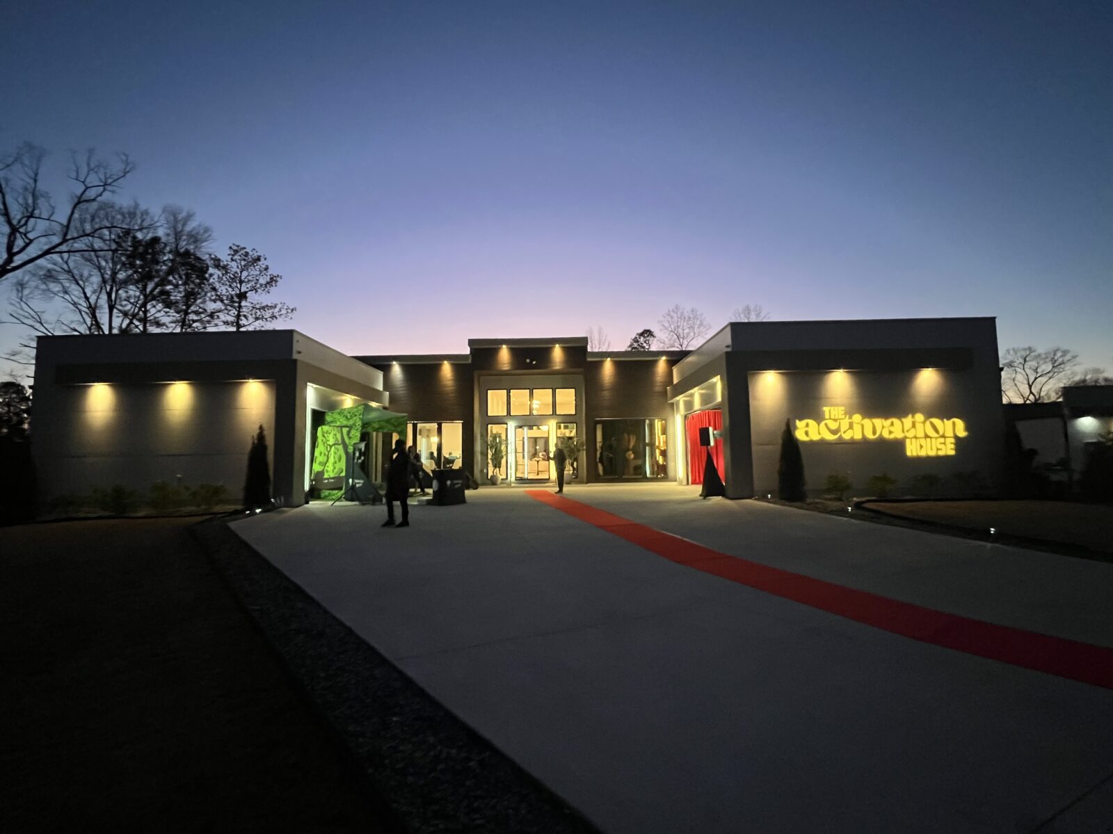 The Activation House in Atlanta illuminated at dusk with architectural lighting and red carpet entrance during a private corporate brand activation supported by Innovent Technologies.