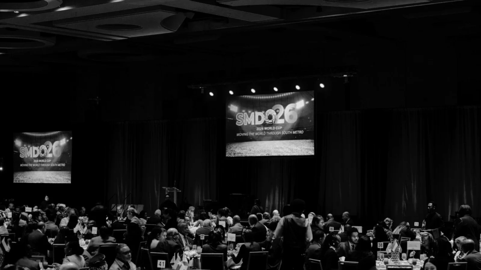 Corporate conference in Atlanta with large projection screens and stage setup during 2026 World Cup planning discussion