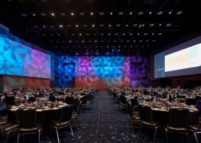 Atlanta civic gala ballroom with custom lighting design, large projection screens, round table seating, and full AV production by Innovent Technologies