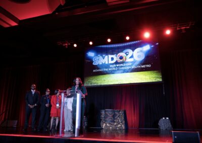 SMDO 2026 luncheon program with red stage lighting and large projection screen backdrop