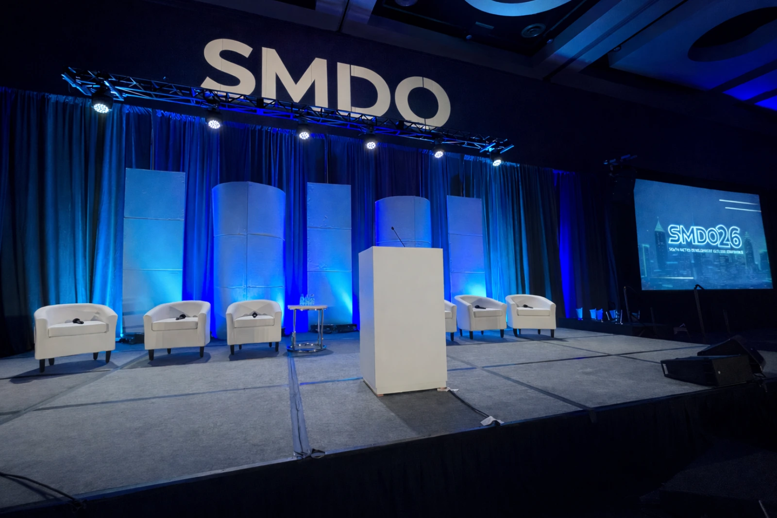 SMDO 2026 Outlook Conference executive stage with scenic panels and dual projection screens