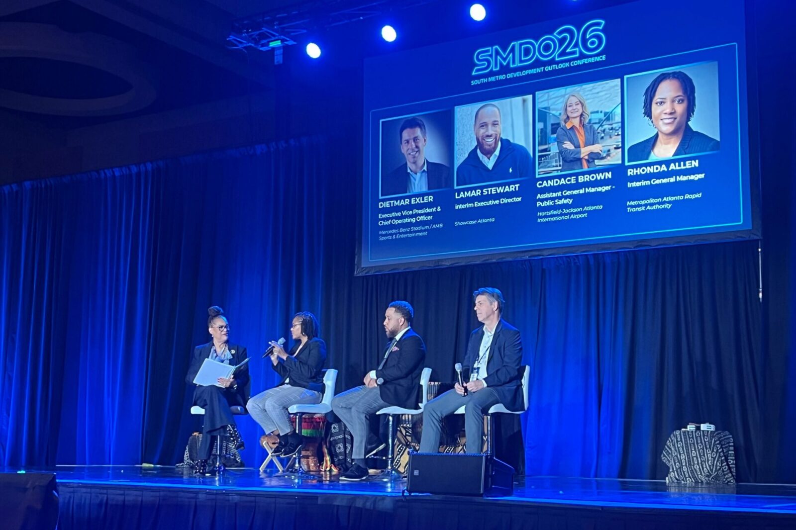 SMDO 2026 panel discussion with speakers on stage and large screen displaying panelist information produced by Innovent Technologies