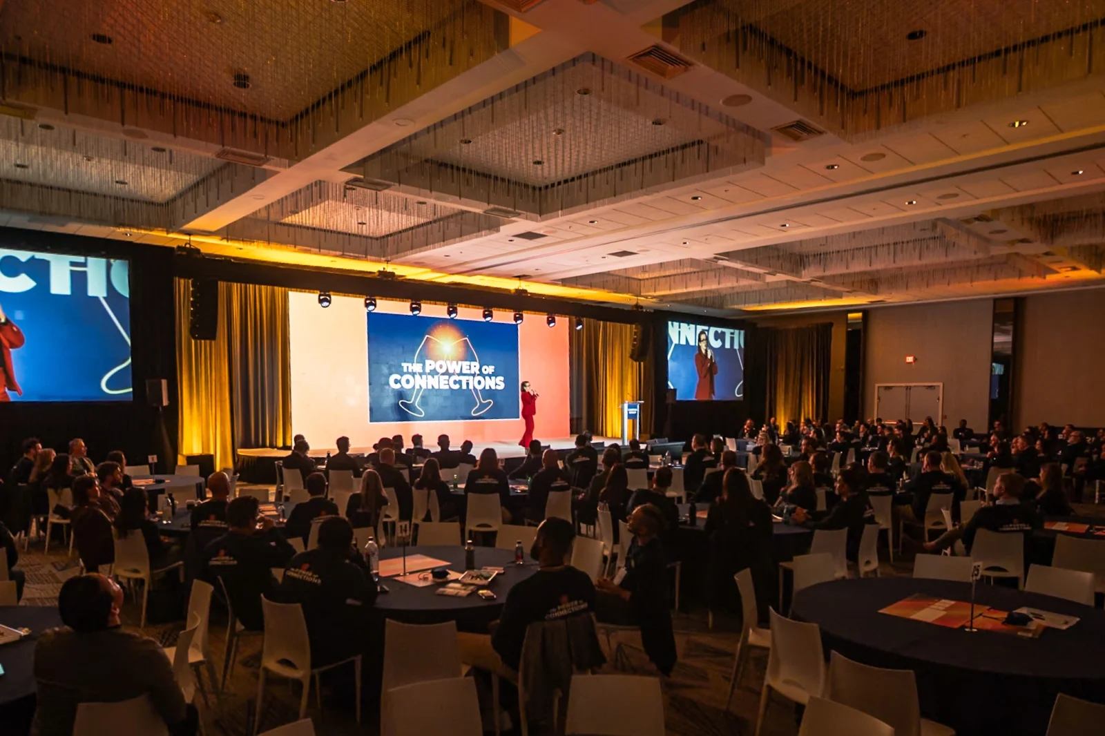 Campari Group general session with presenter on stage, LED screen content, IMAG side screens, and audience in ballroom setting produced by Innovent Technologies