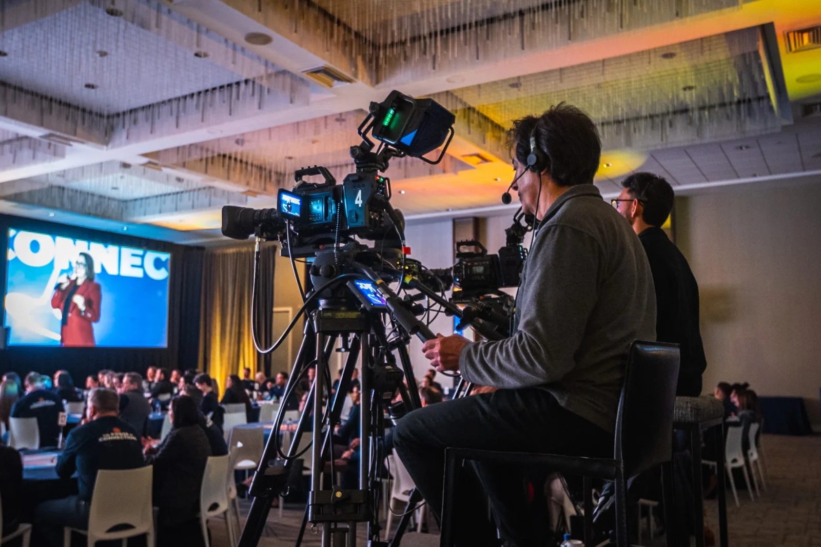 Camera operator capturing live IMAG feed at Campari Group general session with audience and stage presentation in Atlanta by Innovent Technologies