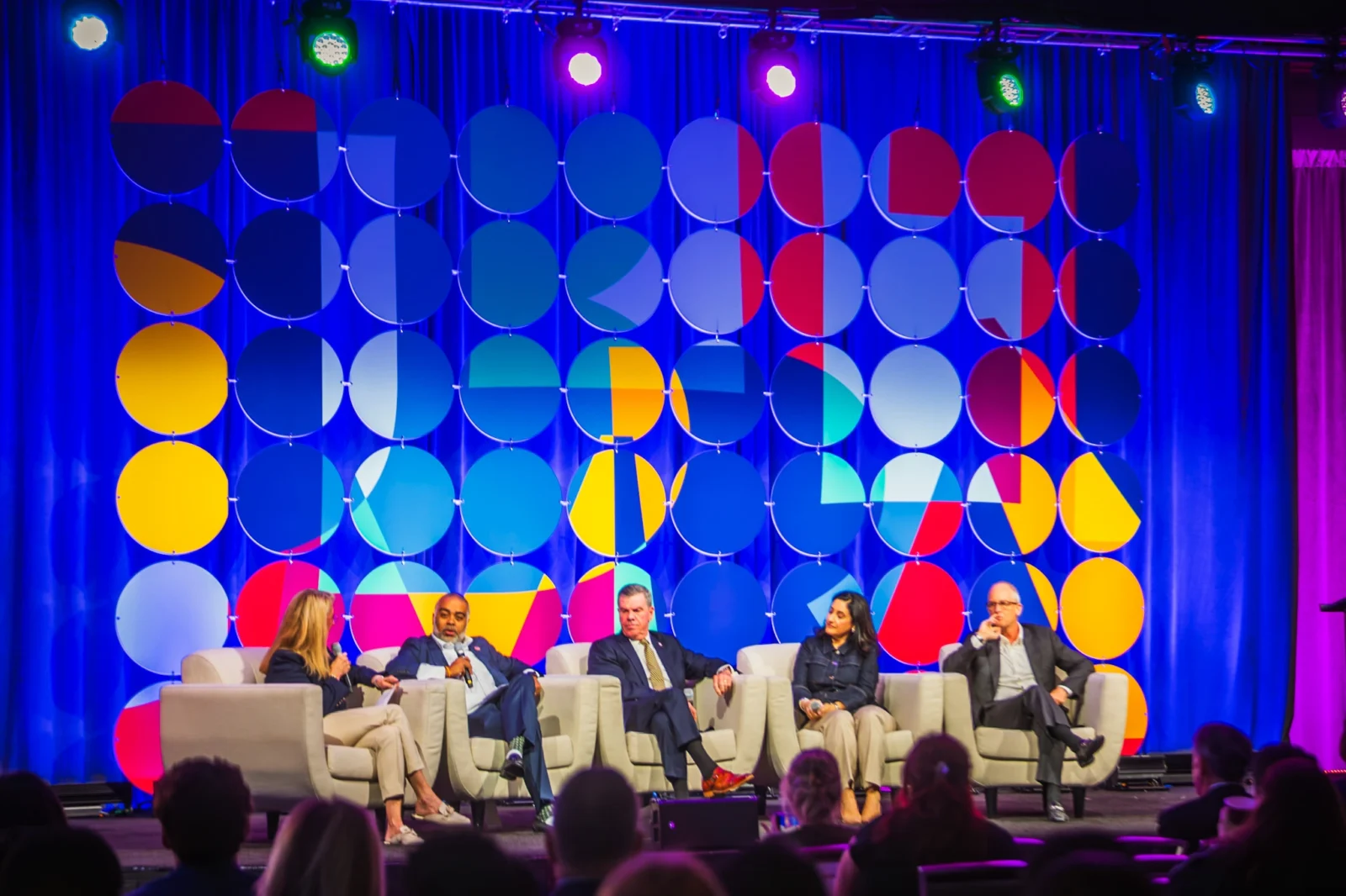 Corporate panel discussion on stage with custom LED backdrop and event lighting design in Atlanta by Innovent Technologies