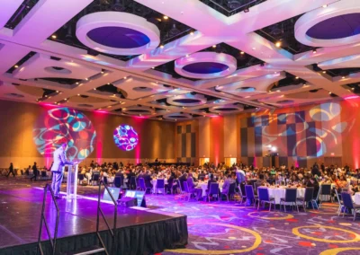 Large gala event with custom lighting gobos, stage presentation, and audience seating by Innovent Technologies