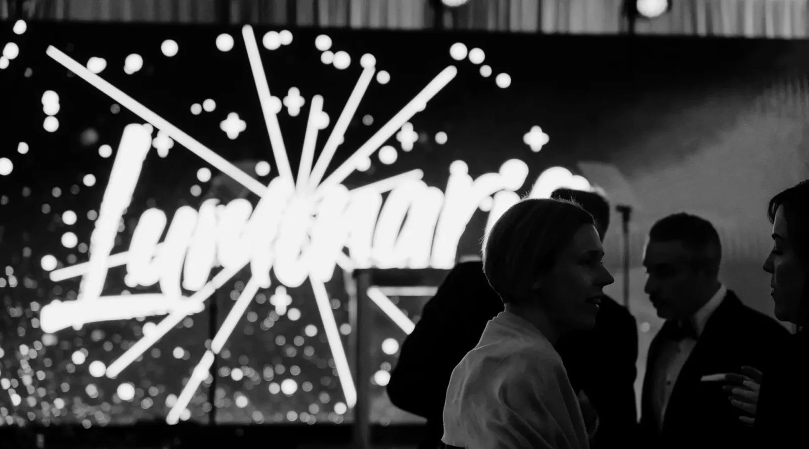 Guests gathered in front of illuminated Luminaria stage with LED visuals during a fundraising gala in Atlanta