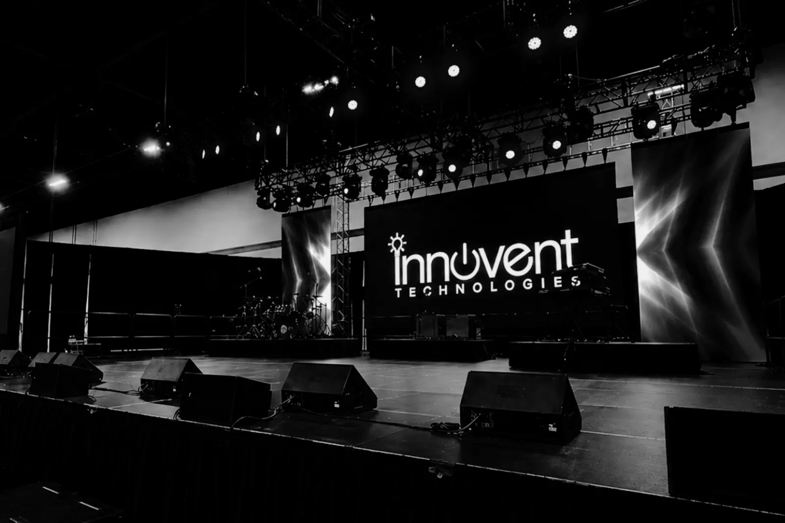 Conference stage with LED video wall, lighting rig, and audio system showing early AV production planning for corporate event