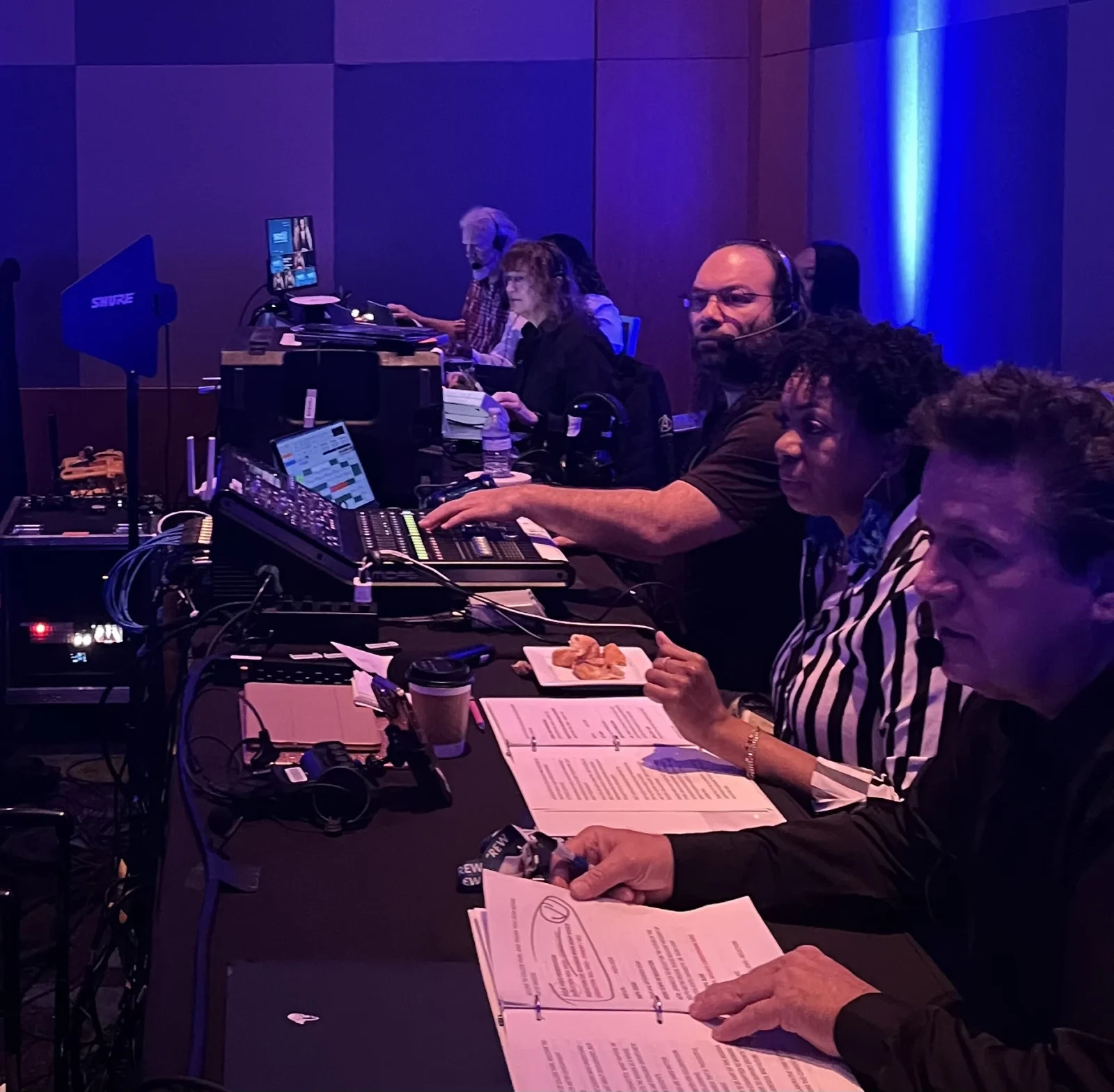 AV production show control team operating lighting, audio, and video systems during a live conference event