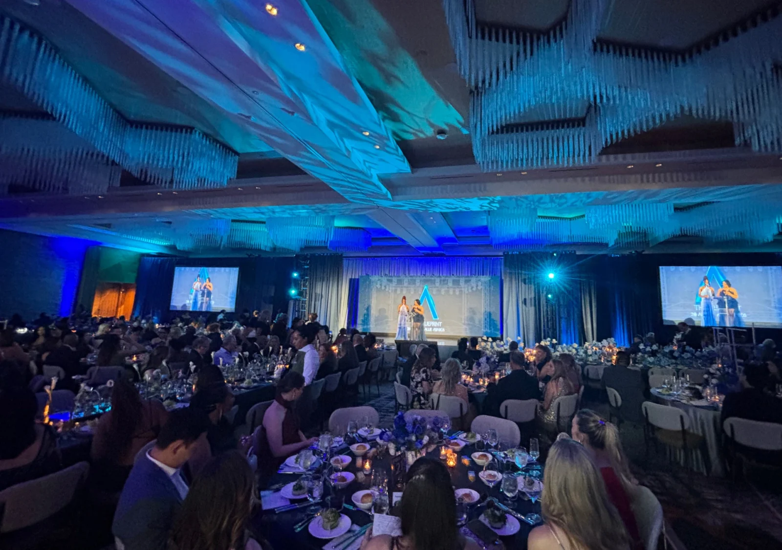 Wide ballroom view of the 2026 Allie Awards with scenic staging, projection screens, lighting design, and live audience during AV production by Innovent Technologies in Atlanta