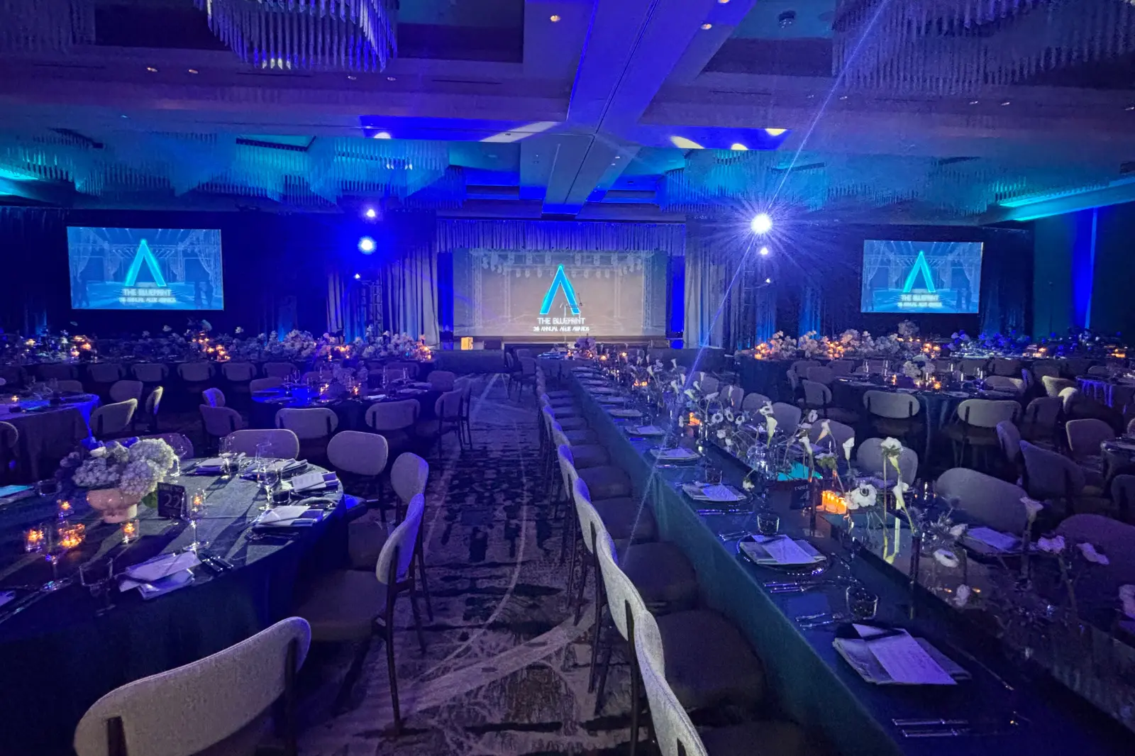 Ballroom production setup at the 2026 Allie Awards featuring stage design, projection screens, lighting, and banquet seating at Hotel Phoenix Atlanta.
