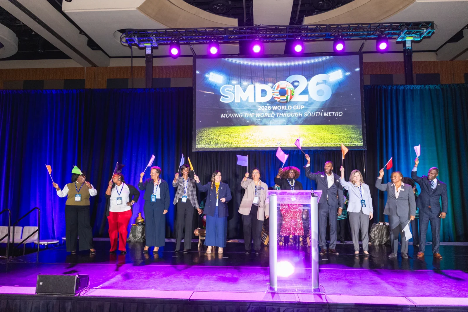 Conference attendees participating in a general session with professional stage design, lighting, and audiovisual production support in Atlanta.