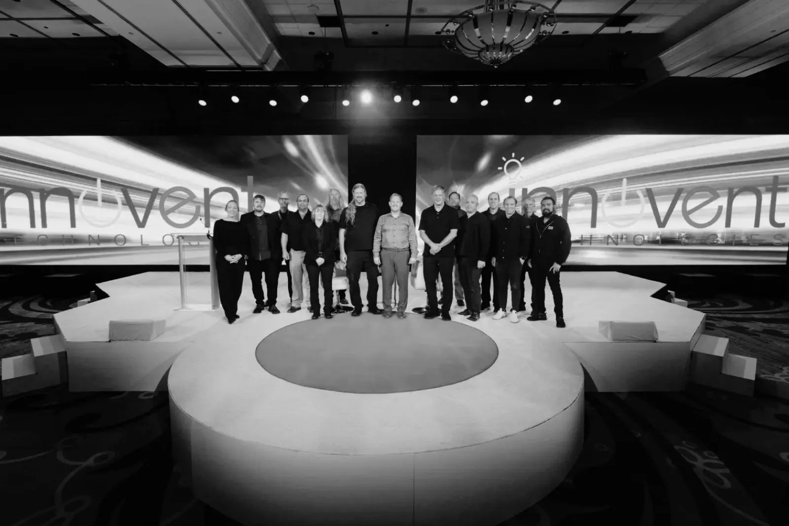 Innovent Technologies production team standing on a corporate conference stage with LED displays, staging, lighting, and audiovisual production elements.