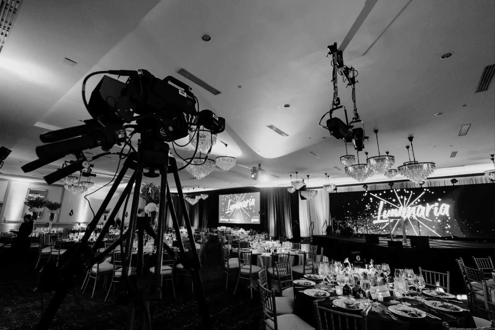 Hotel ballroom AV setup with cameras, stage screens, and production equipment for event internet and Wi-Fi planning